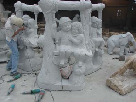 Stone Carving boy and girl on a swing
